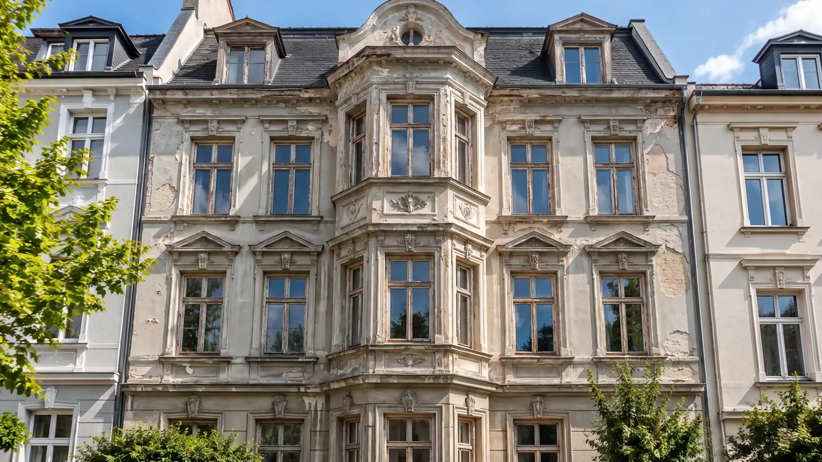 Vorher (Beispiel): Gründerzeitfassade mit abblätternder Farbe, Wasserflecken und grauem Putz